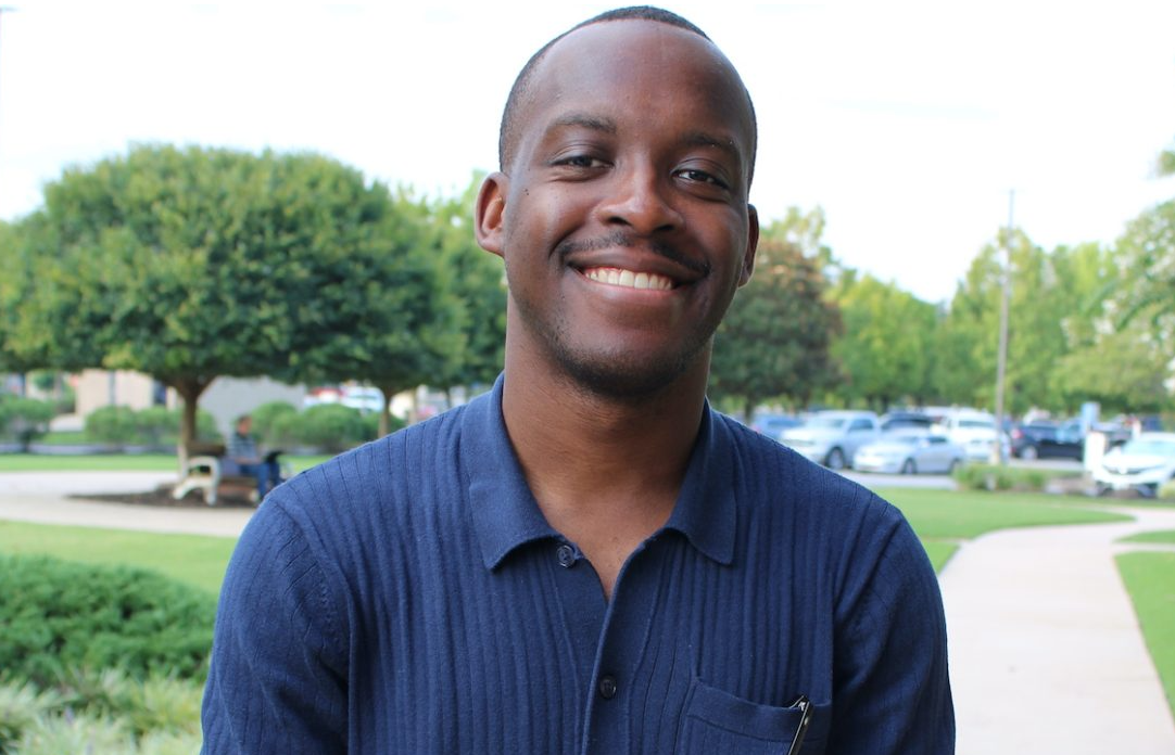 man in a blue shirt sitting outside