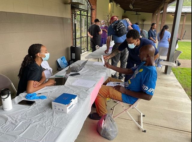 students sitting at a long table with a patient