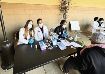 Students sitting a table waiting to see patients at the Empower clinic