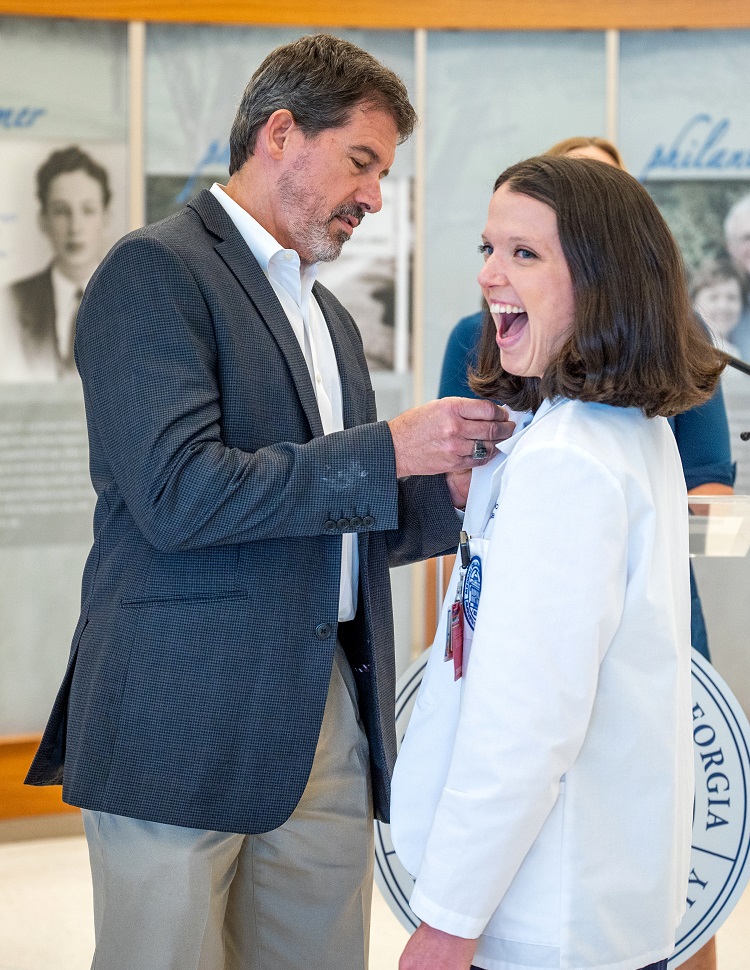 Dr. Michael Brands presenting a pin to a medical student