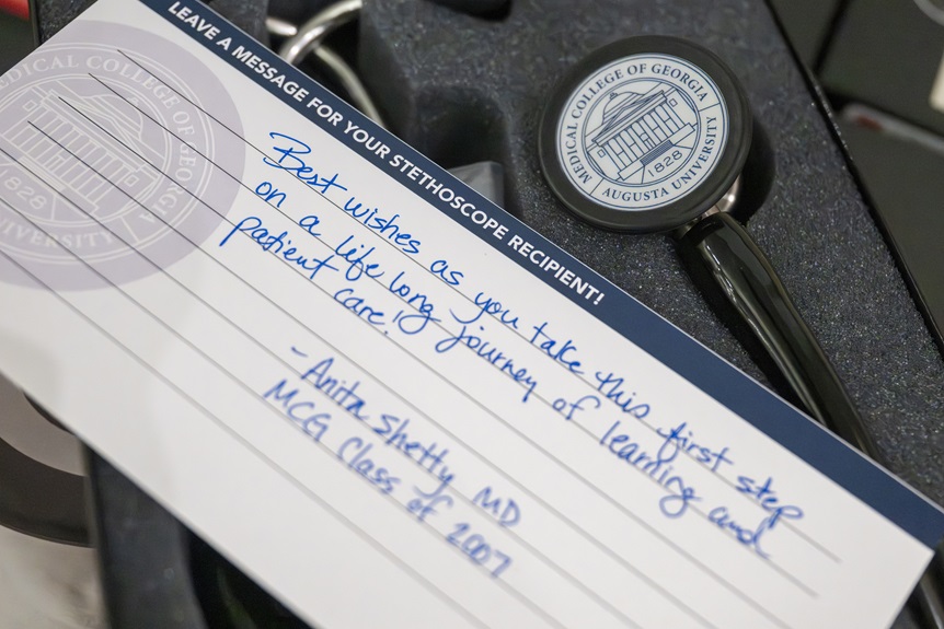 2026 Stethoscope presentation photos of students receiving, writing thank you notes, reading notes from donors and trying out their new stethoscopes on each other.