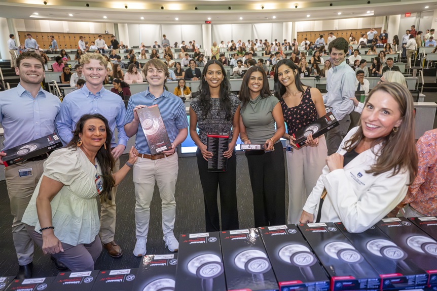2026 Stethoscope presentation photos of students receiving, writing thank you notes, reading notes from donors and trying out their new stethoscopes on each other.
