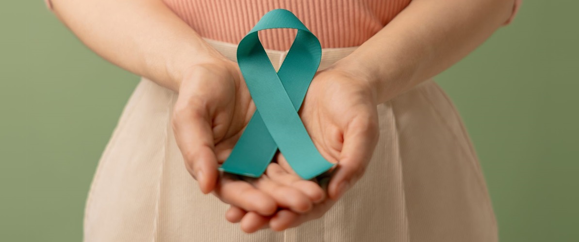 Woman holds a teal ribbon that represents gynecological cancer