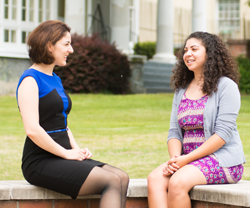 Ana Merloiu and Christie Sanchez, two students at Augusta University, sitting on a bench outside of Allgood Hall