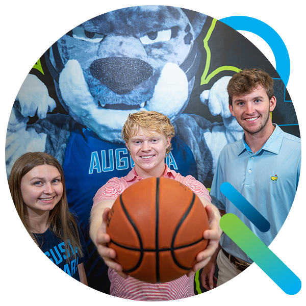 Kinesiology students hold a basketball at Christenberry fieldhouse