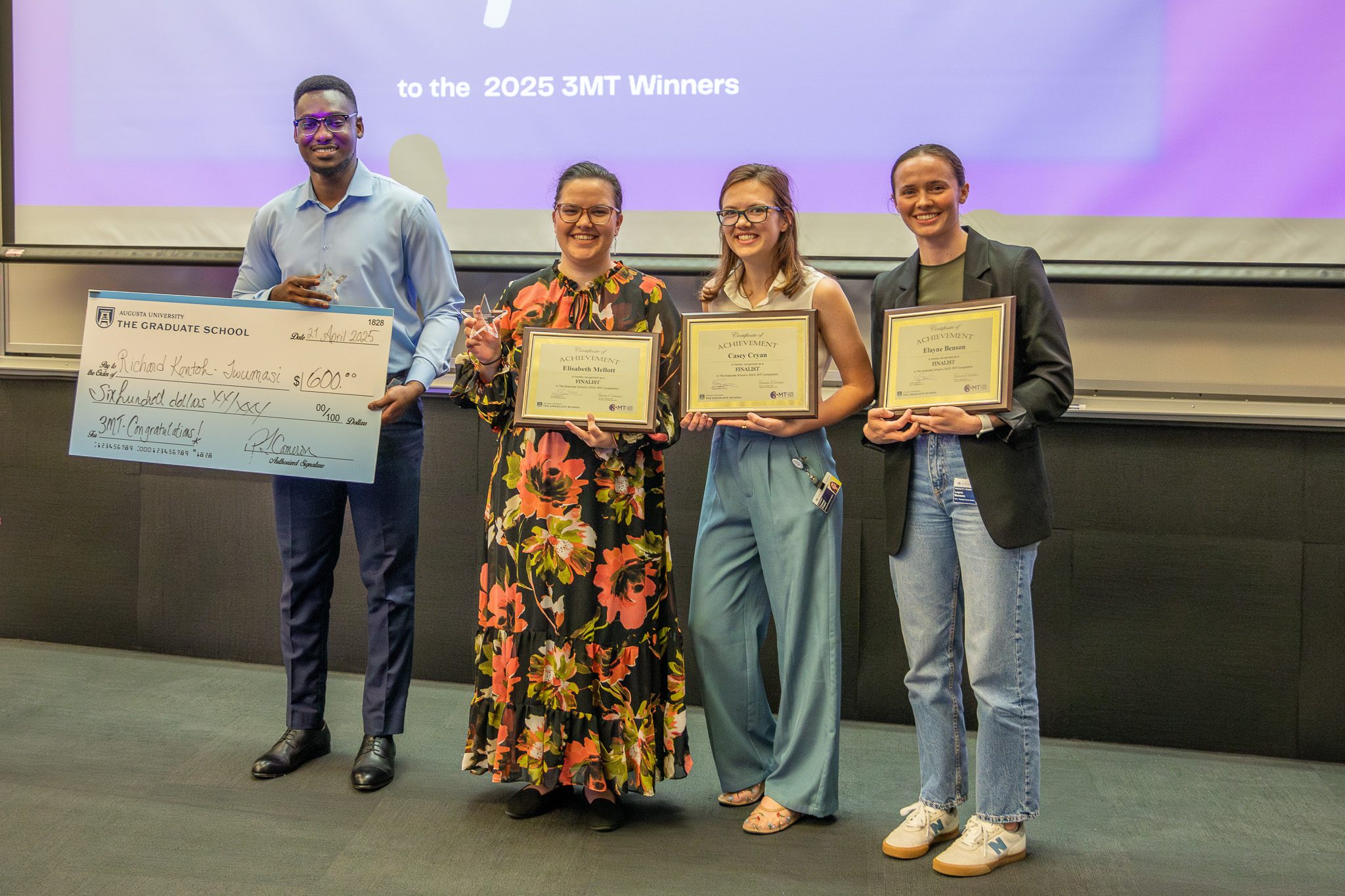 Students smiling with award
