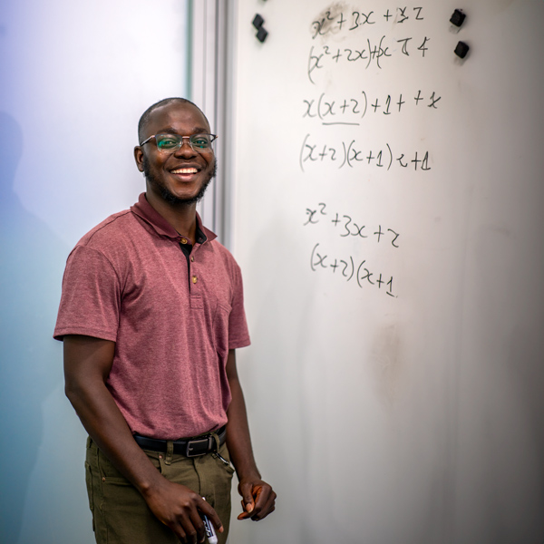 Selassie Wonder King Hatekah in front of a whiteboard