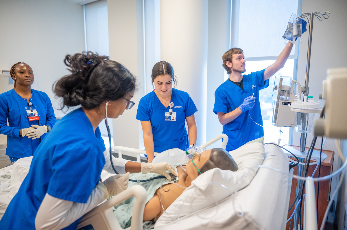 Nursing students attend to a simulated patient in the SIM Center on the Health Sciences campus