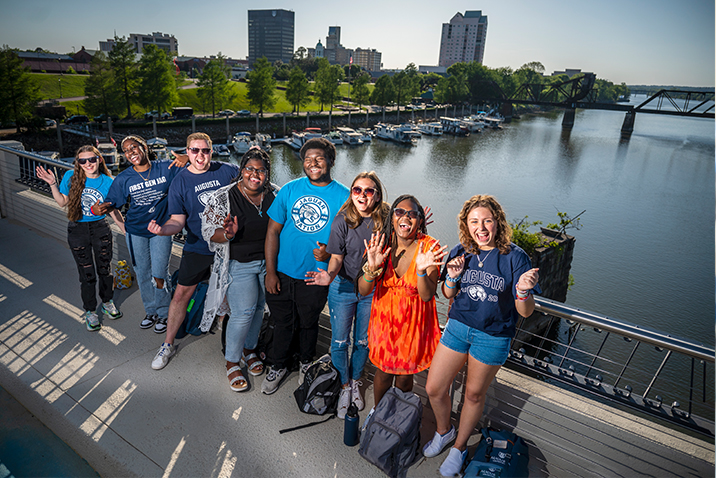 Group photo of students smiling on bridge