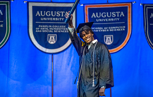 Graduate celebrates as he walks across the stage