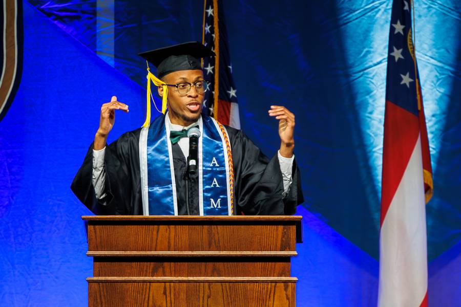 male graduate speaking at podium