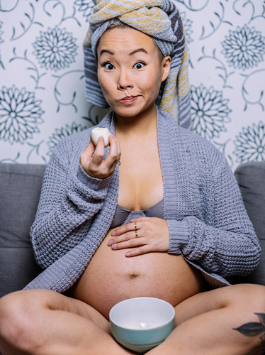 pregnant woman makes a silly face holding a boiled egg