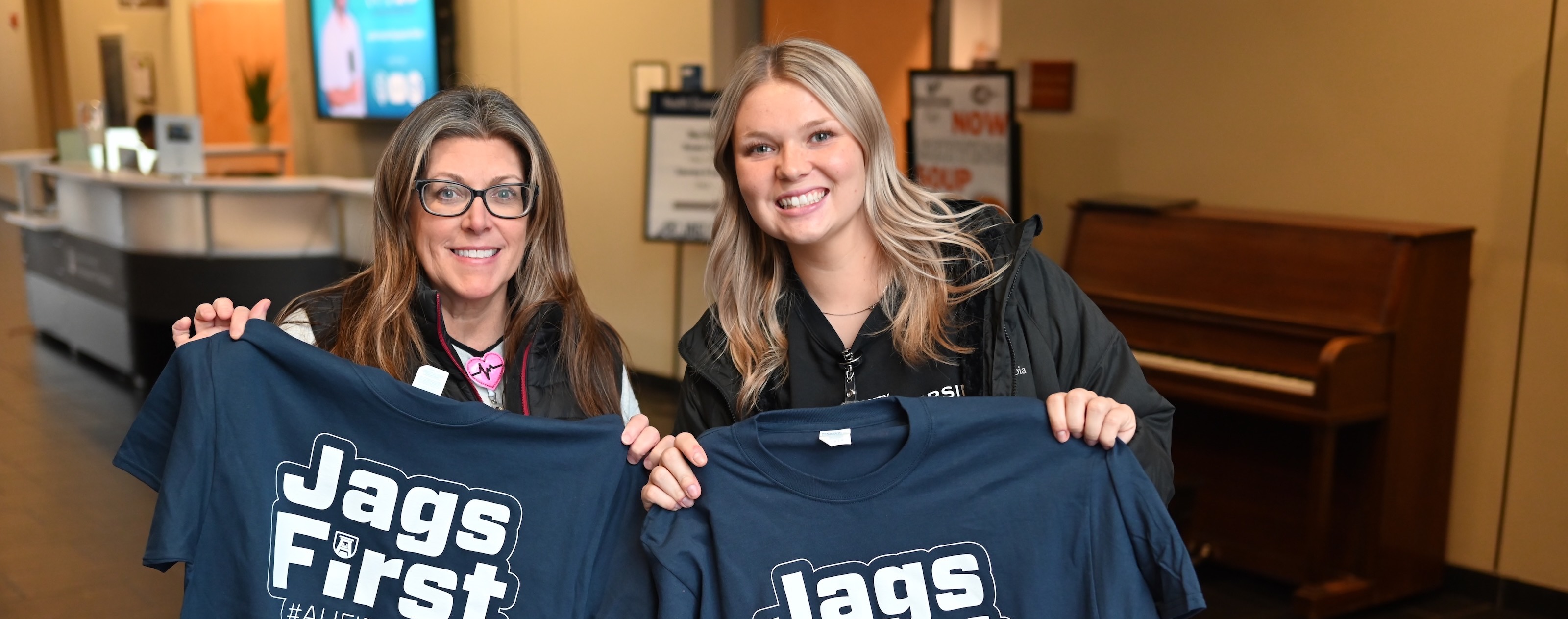 students holding up #JagsFirst t-shirts