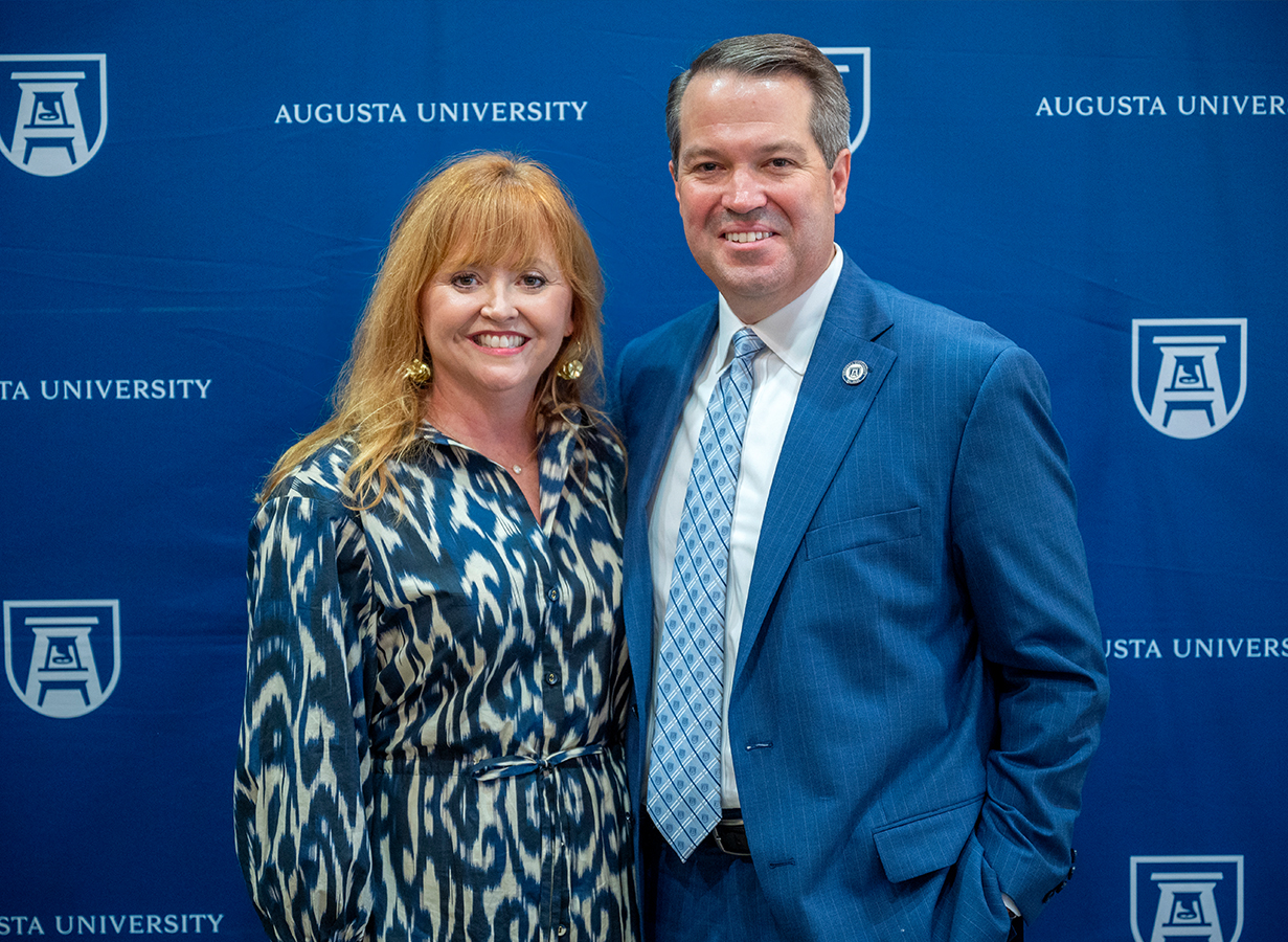 Russel and Karen Keen stand in front of an AU Backdrop