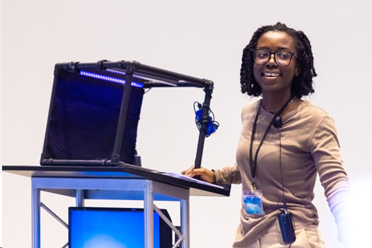 Women demonstrating her invention in front of audience