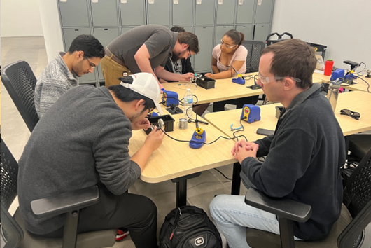 Group of students soldering electronics in The Garage