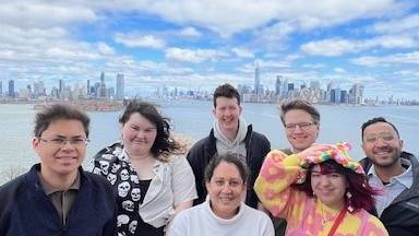students pose in front of the new york skyline