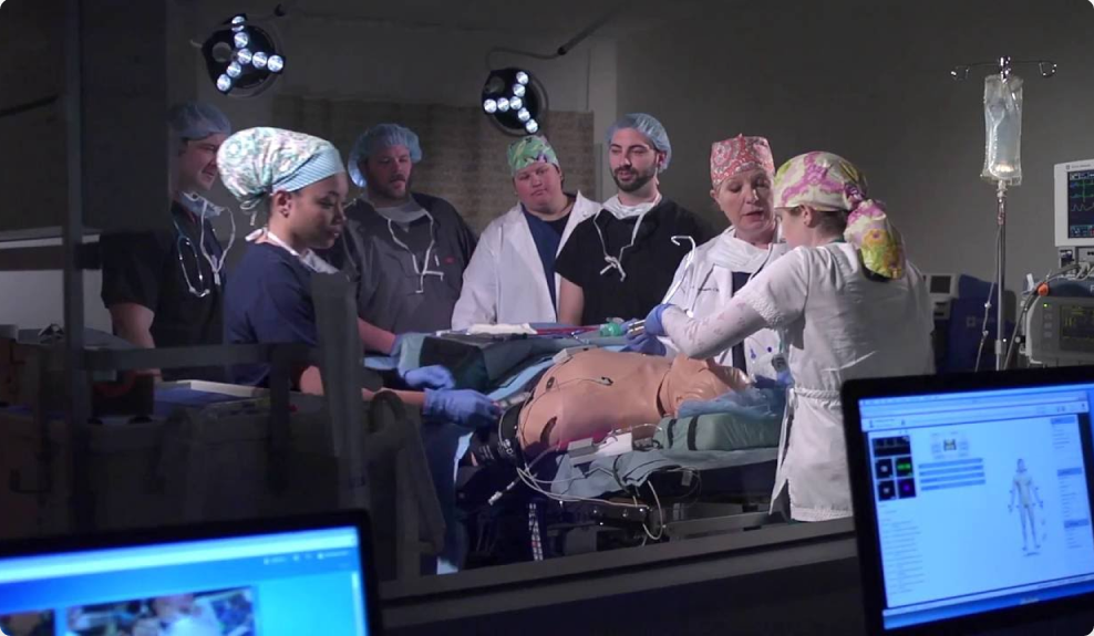 Healthcare professionals practice on a dummy in a simulation lab