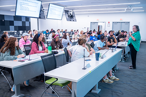 A psychology professor addresses rows of students seating a classroom auditorium